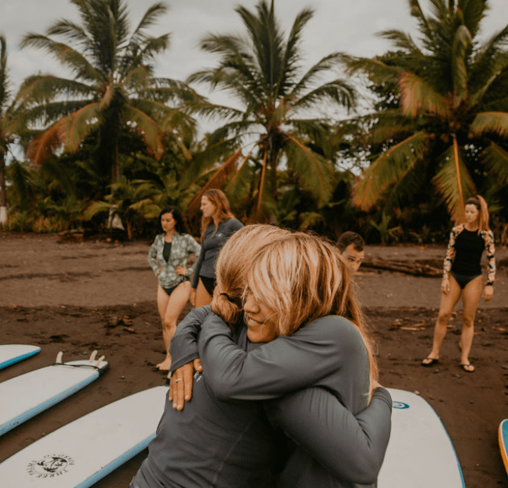 SurfHug_730x700 Women embracing after a surf session.
