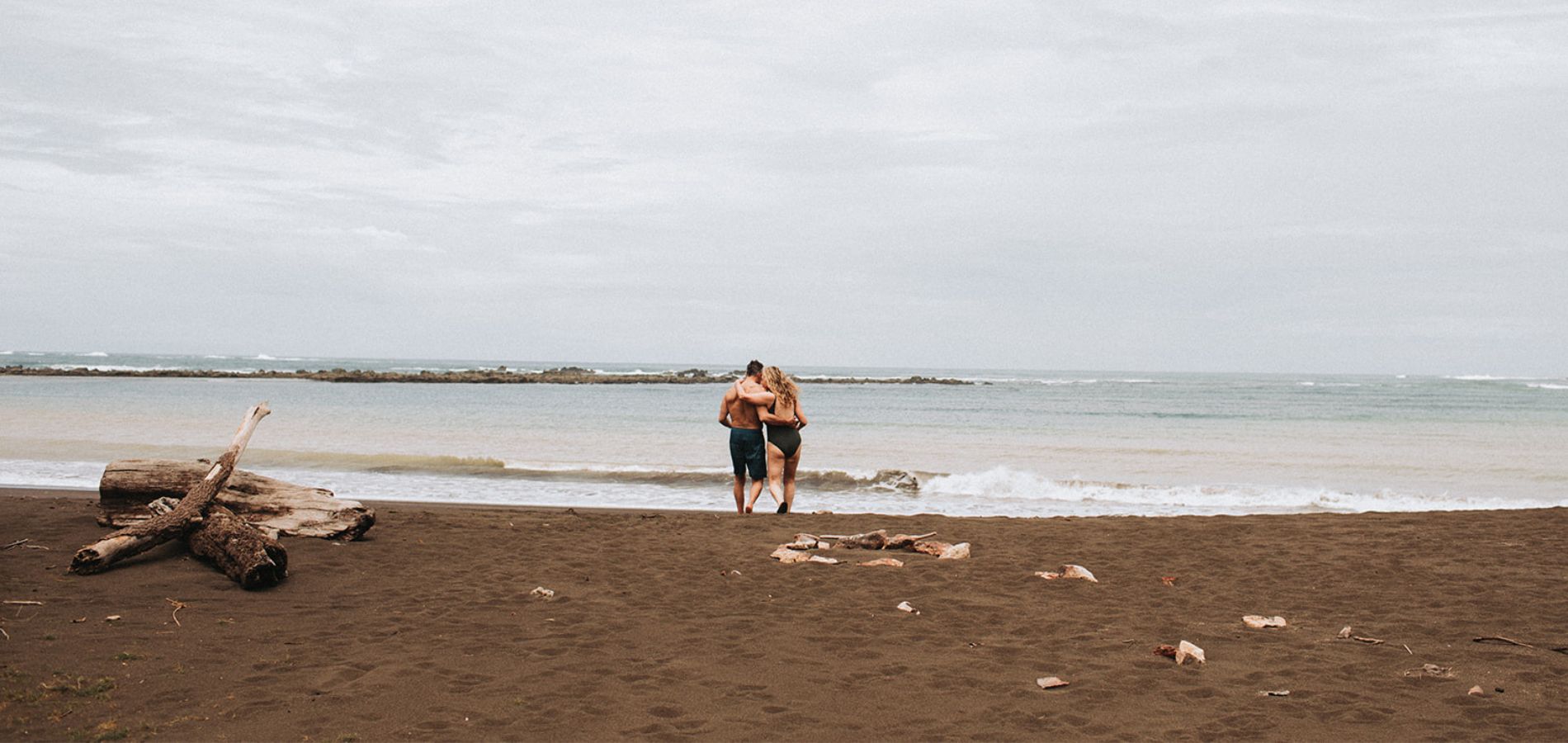 Pareja en la playa_1900x900 Couple embracing on secluded beach