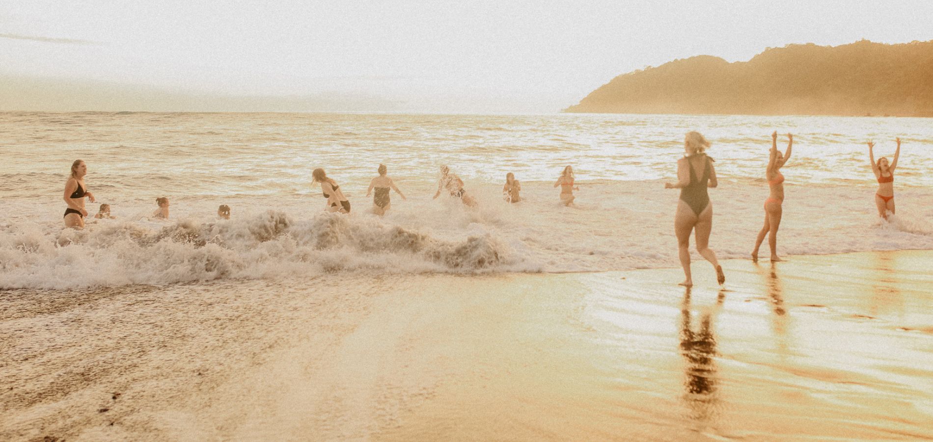 Women celebrating on the beach at sunset